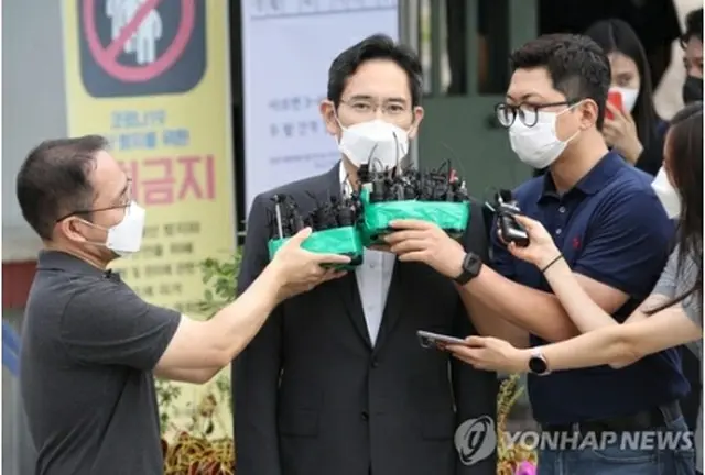 ソウル拘置所前で報道陣に囲まれる李氏＝１３日、義王（聯合ニュース）