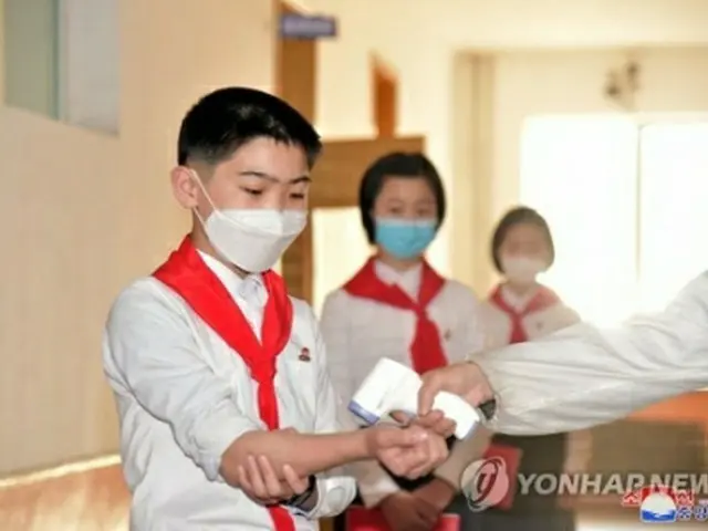 平壌市内の中学校でマスクをつけた生徒らが体温を測っている＝（朝鮮中央通信＝聯合ニュース）≪転載・転用禁止≫