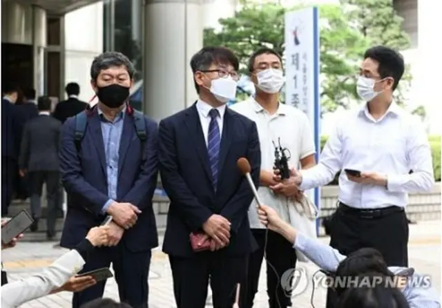 判決後、地裁前で記者団の取材に応じる原告の代理人ら＝8日、ソウル（聯合ニュース）