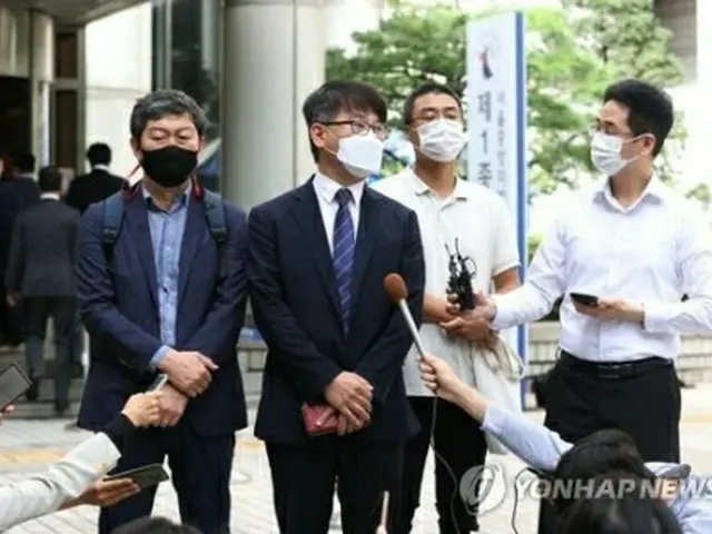 判決後、地裁前で記者団の取材に応じる原告の代理人ら＝8日、ソウル（聯合ニュース）