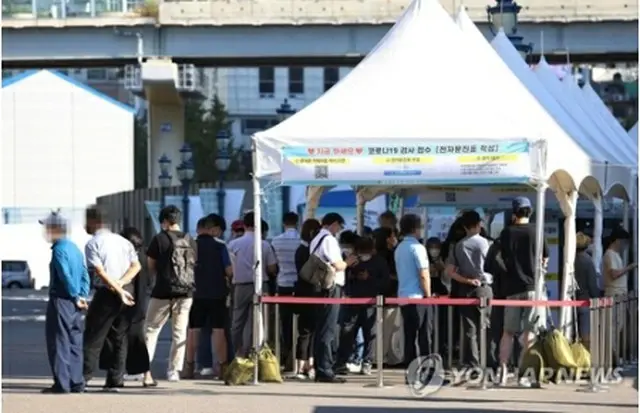 ソウル駅前の広場に設置されている臨時検査所で、市民が順番を待っている＝２３日、ソウル（聯合ニュース）