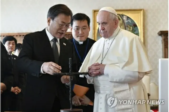 会談で教皇に平和の十字架について説明する文大統領（左、ローマ法王庁提供）＝（聯合ニュース）≪転載・転用禁止≫