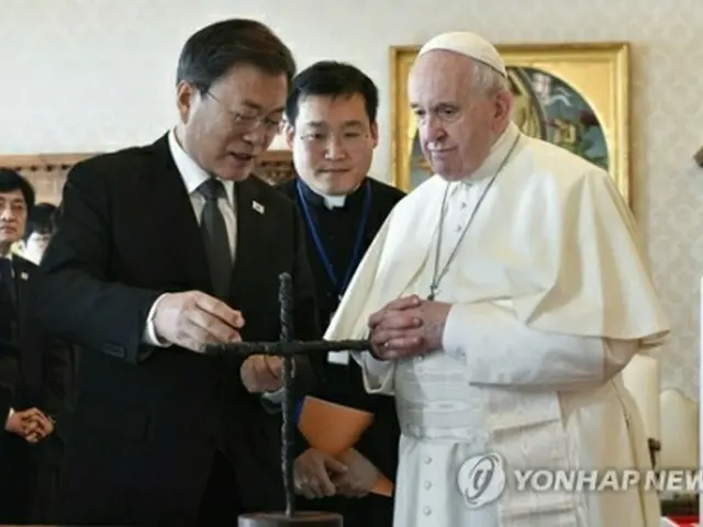 会談で教皇に平和の十字架について説明する文大統領（左、ローマ法王庁提供）＝（聯合ニュース）≪転載・転用禁止≫