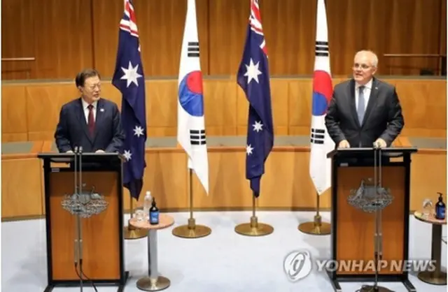 オーストラリアのモリソン首相（右）と共同記者会見を行う文大統領＝１３日、キャンベラ（聯合ニュース）