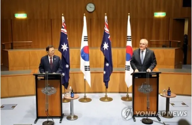 首脳会談後、共同記者会見を行う文統領（左）とモリソン首相＝13日、キャンベラ（聯合ニュース）