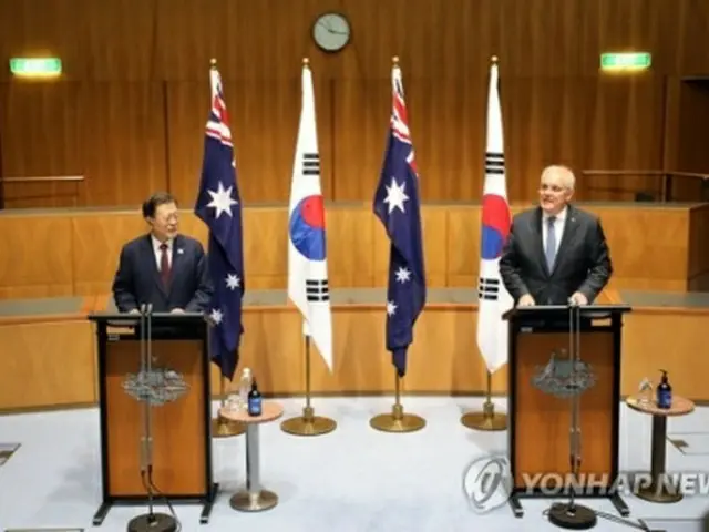 首脳会談後、共同記者会見を行う文統領（左）とモリソン首相＝13日、キャンベラ（聯合ニュース）