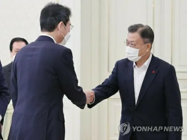 握手を交わす文大統領（右）と李在鎔氏＝２７日、ソウル（聯合ニュース）