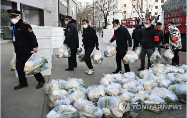 先月２９日、西安の住民に生活必需品を届ける当局者＝（新華社＝聯合ニュース）