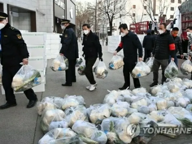 先月２９日、西安の住民に生活必需品を届ける当局者＝（新華社＝聯合ニュース）