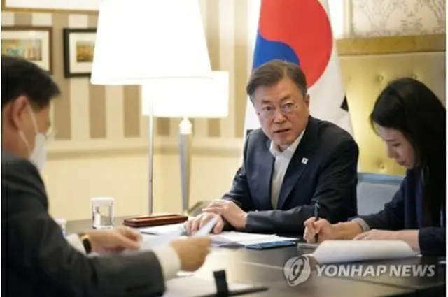 文大統領はドバイのホテル内の会議室で、アブダビのムハンマド皇太子と電話で会談した＝17日、ドバイ（聯合ニュース）