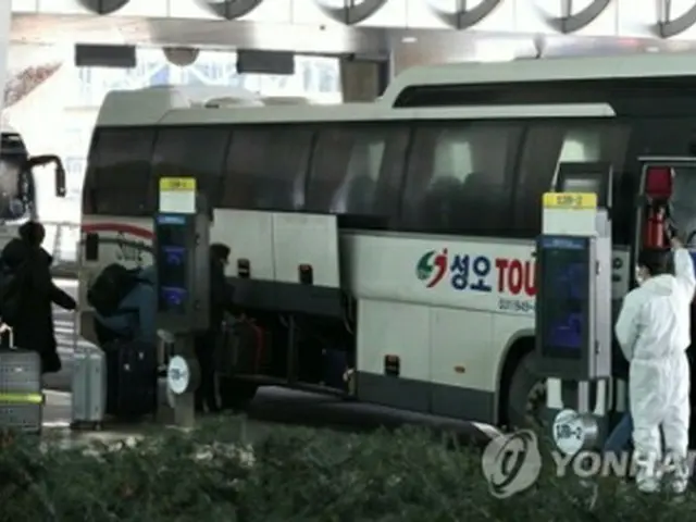 ２０日、仁川国際空港で専用バスに乗車する入国者＝（聯合ニュース）