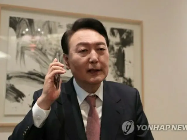 自宅でバイデン米大統領と電話する尹氏（国民の力提供）＝１０日、ソウル（聯合ニュース）≪転載・転用禁止≫