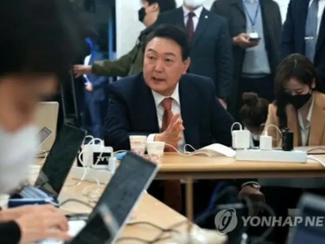次期政権への移行を準備する政権引き継ぎ委員会の事務所前に設置された臨時記者室に立ち寄り、記者団の質問に答える尹氏（国会写真記者団）＝24日、ソウル（聯合ニュース）