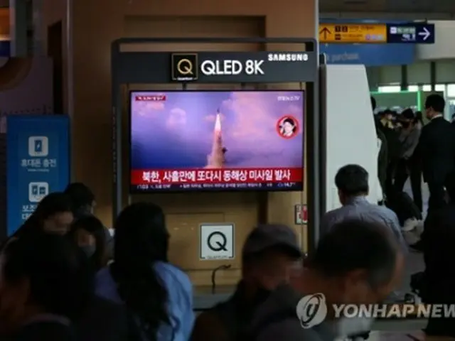 ソウル駅で北朝鮮の弾道ミサイル発射のニュースを見つめる人々＝７日、ソウル（聯合ニュース）