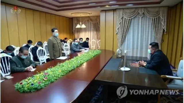 北朝鮮の朝鮮中央テレビが１３日に公開した会議の様子。金正恩氏（右）もマスクを着用している＝（聯合ニュース）≪転載・転用禁止≫