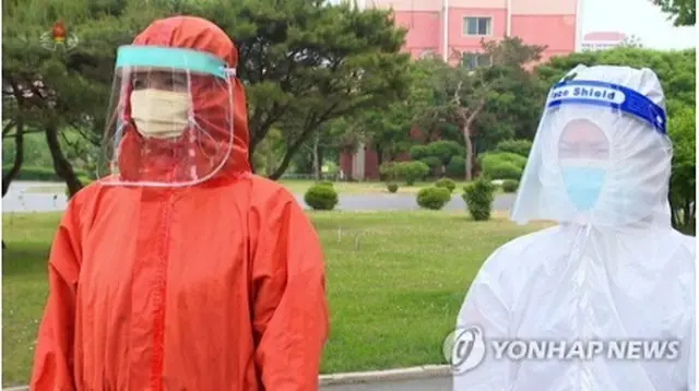 フェースシールドと書かれた防護具を着用している北朝鮮の防疫関係者（朝鮮中央テレビの映像から）＝（聯合ニュース）≪転載・転用禁止≫