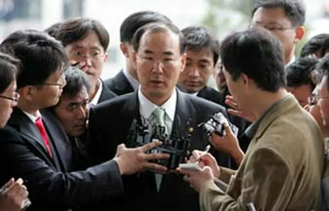 釜山地検に出頭し取材陣に囲まれる全庁長＝1日、釜山（聯合）