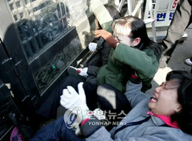 不合格処分が決まり、教育庁の外で泣き崩れる母親ら＝16日、水原（聯合）