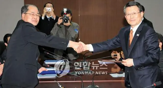 合意文を交換する白鍾天安保室長（右）と北朝鮮の朴松男国土環境保護相＝29日、ソウル（聯合）
