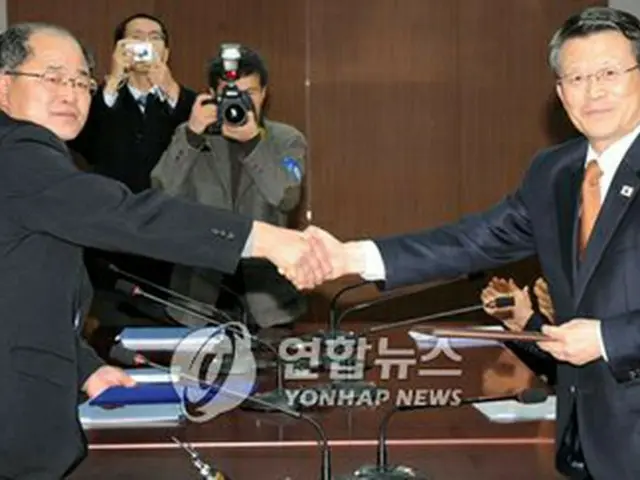 合意文を交換する白鍾天安保室長（右）と北朝鮮の朴松男国土環境保護相＝29日、ソウル（聯合）