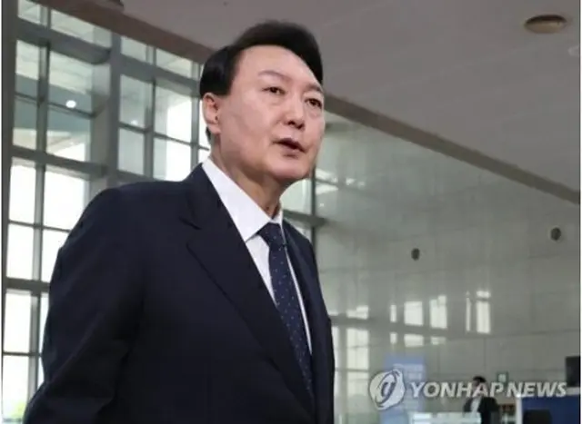 大統領室庁舎に出勤し、記者団の質問に答える尹大統領＝21日、ソウル（聯合ニュース）