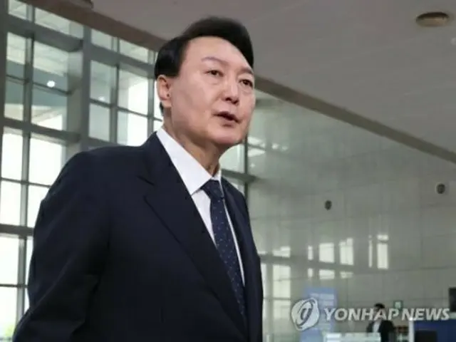 大統領室庁舎に出勤し、記者団の質問に答える尹大統領＝21日、ソウル（聯合ニュース）
