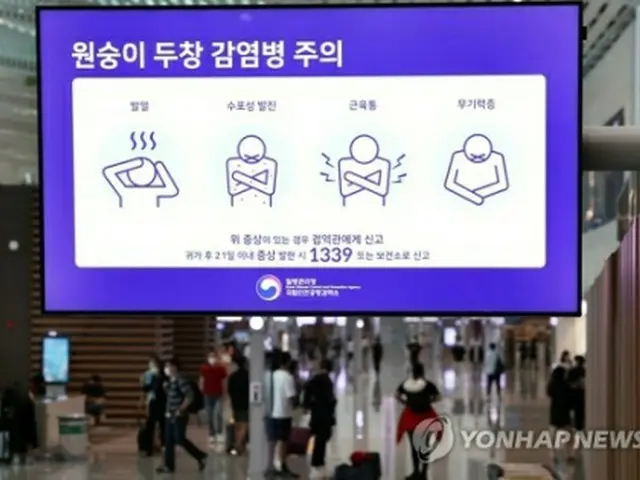 仁川空港のモニターに表示されたサル痘に関連した注意喚起の映像。感染が疑われる場合は届け出るよう呼び掛けている＝２３日、仁川（聯合ニュース）