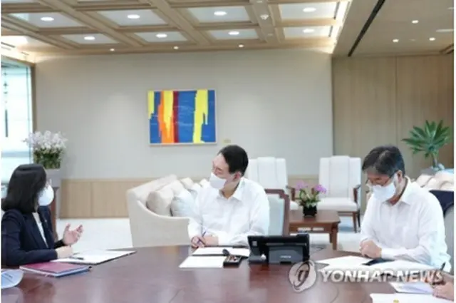 金氏（左）から女性家族部の報告を受ける尹大統領（中央・大統領室提供）＝（聯合ニュース）≪転載・転用禁止≫
