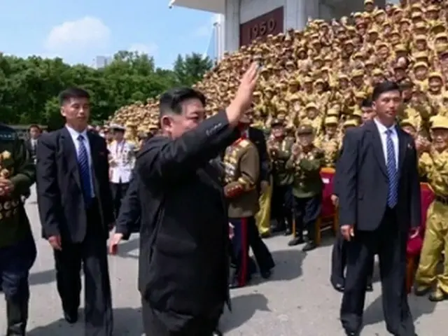 ２８日に開かれた全国老兵大会の参加者に手を振る金正恩氏。金氏のそばで警護員が警護に当たっている＝（朝鮮中央通信＝聯合ニュース）≪転載・転用禁止≫