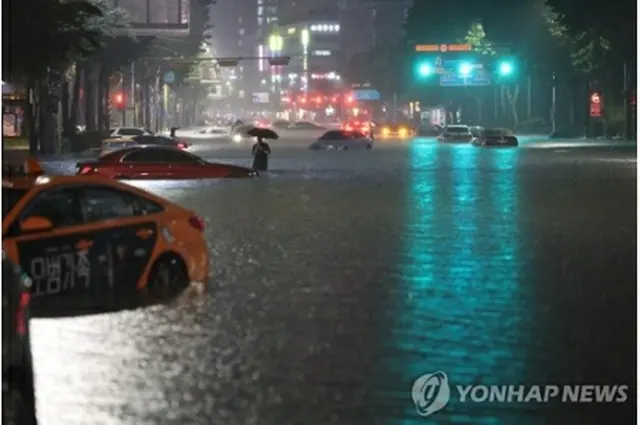 大雨で道路が冠水したソウル市江南区の繁華街付近＝８日、ソウル（聯合ニュース）