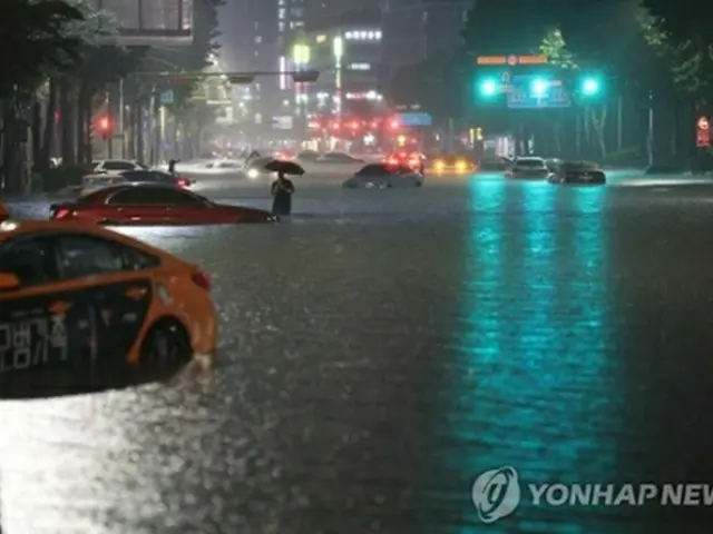 大雨で道路が冠水したソウル市江南区の繁華街付近＝８日、ソウル（聯合ニュース）