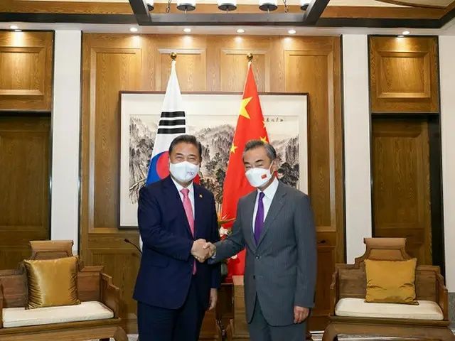 韓国の朴振外相（左）と中国の王毅 国務委員兼外相が9日（現地時間）、中国山東省青島のホテルで会談を前に握手している様子（画像提供:wowkorea）