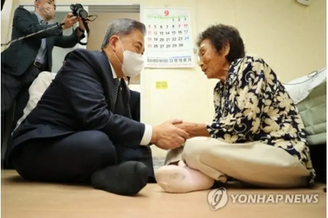 梁錦徳（ヤン・クムドク）さん（右）の手を取る朴氏（共同取材）＝２日、光州（聯合ニュース）
