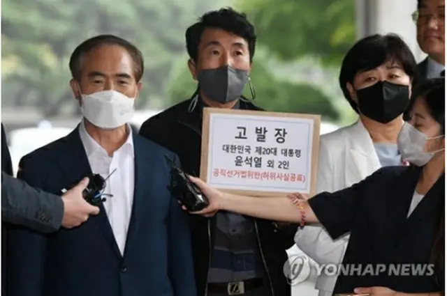 告発状を提出するために訪れたソウル中央地検前で記者団の質問に答える共に民主党の関係者（国会写真記者団）＝５日、ソウル（聯合ニュース）