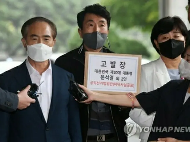 告発状を提出するために訪れたソウル中央地検前で記者団の質問に答える共に民主党の関係者（国会写真記者団）＝５日、ソウル（聯合ニュース）