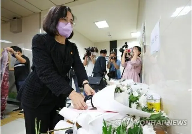 ストーカー殺人事件が発生した新堂駅に設置された被害者の追悼スペースに献花する女性家族部の金賢淑長官＝１６日、ソウル（聯合ニュース）