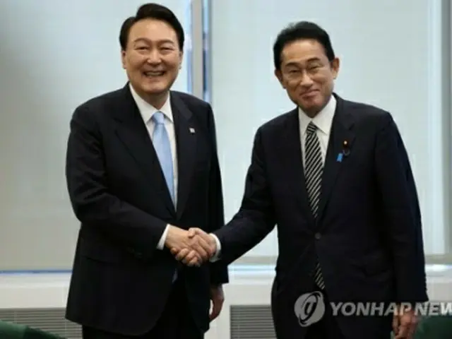 握手を交わす尹大統領（左）と岸田首相＝２１日、ニューヨーク（聯合ニュース）