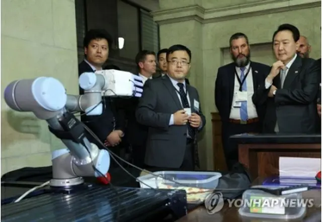 トロント大で研究中のロボットの実演を見る尹大統領（右端）＝２２日、トロント（聯合ニュース）