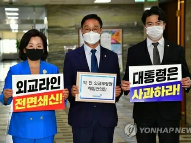 朴氏の解任決議案を手にする共に民主党の議員（共同取材）＝２７日、ソウル（聯合ニュース）