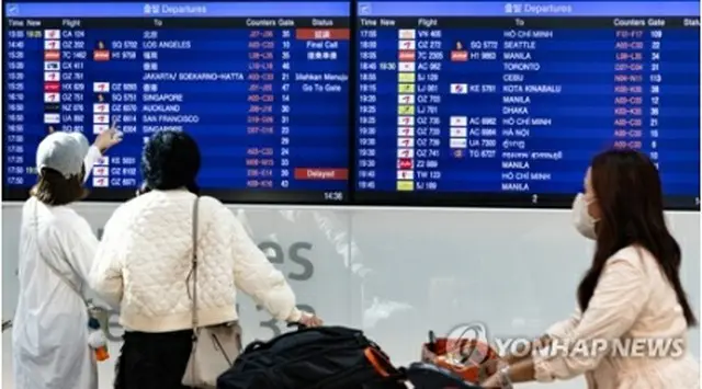 韓国の仁川国際空港でフライト情報を確認する旅行客＝10日、仁川（聯合ニュース）