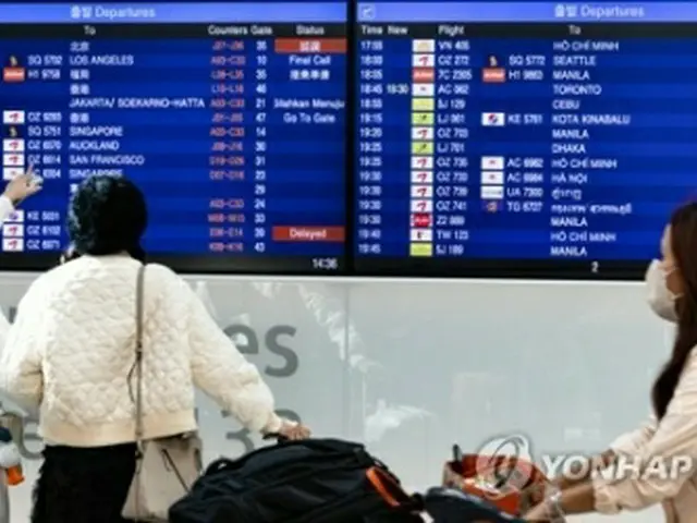 韓国の仁川国際空港でフライト情報を確認する旅行客＝10日、仁川（聯合ニュース）