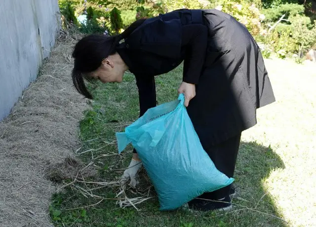 児童虐待死亡事件の被害者の墓を非公開で訪れ、ゴミを片付けるキム・ゴニ大統領夫人（画像提供:wowkorea）