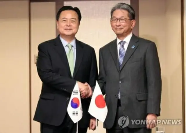 握手を交わす趙氏（左）と森氏（共同取材団）＝２５日、東京（聯合ニュース）≪転載・転用禁止≫