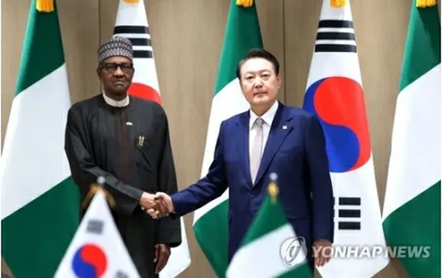 握手する尹大統領（右）とブハリ大統領＝２６日、ソウル（聯合ニュース）