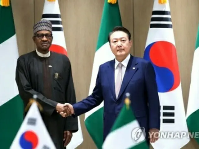 握手する尹大統領（右）とブハリ大統領＝２６日、ソウル（聯合ニュース）