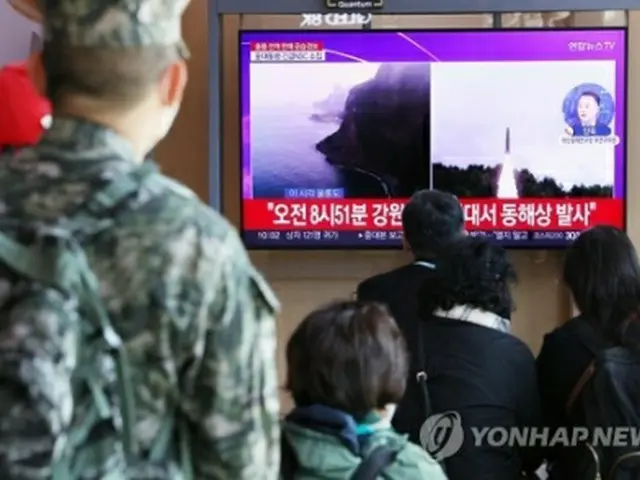 ソウル駅で、北朝鮮による弾道ミサイル発射を伝えるニュースを見る市民＝２日、ソウル（聯合ニュース）