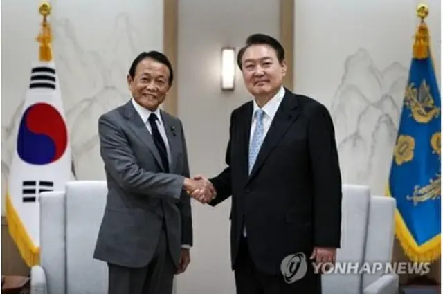 握手を交わす尹大統領と麻生氏（大統領室提供）＝（聯合ニュース）≪転載・転用禁止≫
