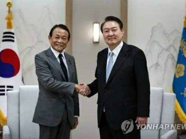 握手を交わす尹大統領と麻生氏（大統領室提供）＝（聯合ニュース）≪転載・転用禁止≫
