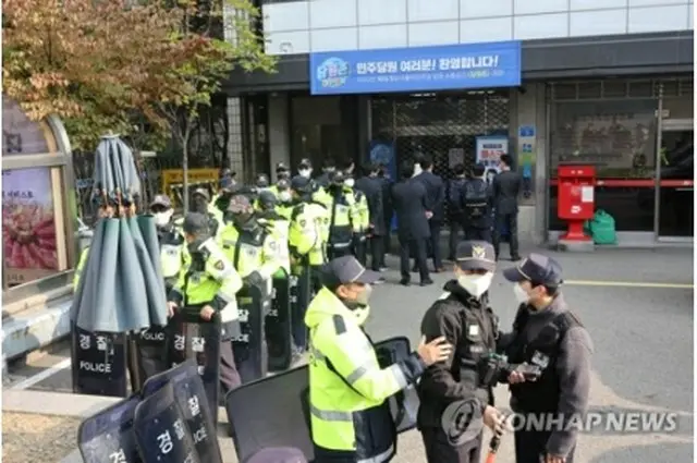鄭氏の勤務先を家宅捜索するため、共に民主党本部の入り口で待機する検察関係者＝９日、ソウル（聯合ニュース）