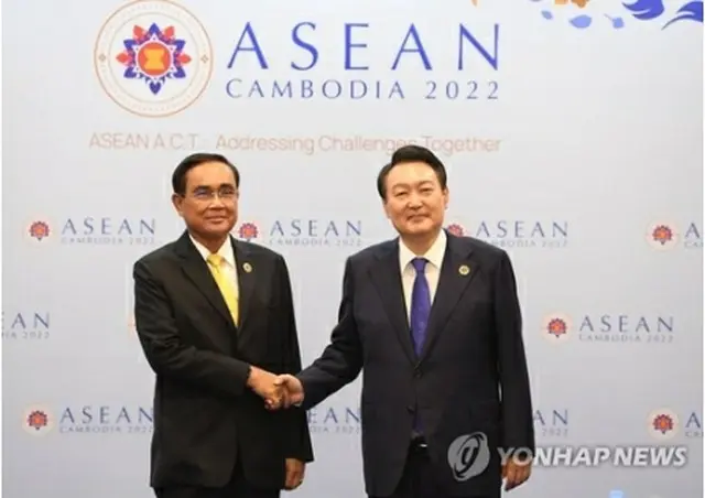 握手する尹大統領（右）とプラユット首相＝１１日、プノンペン（聯合ニュース）